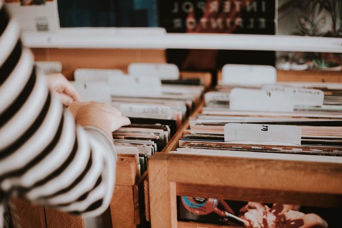 record store person holding folders record shop